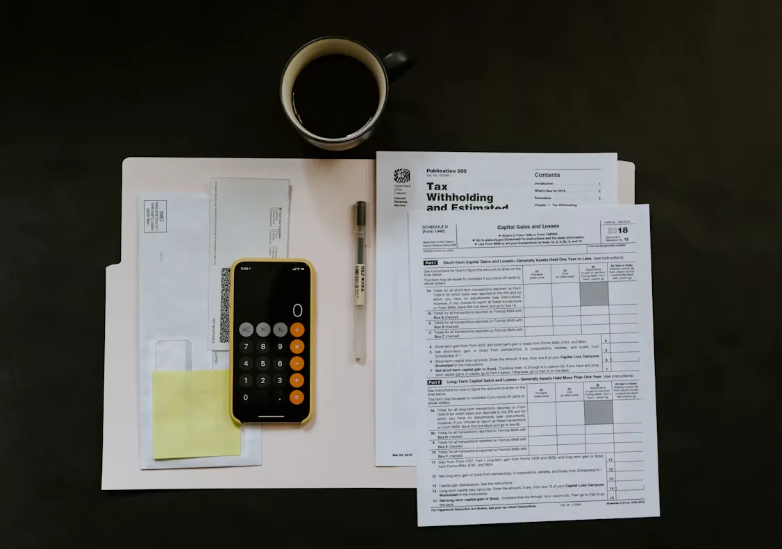 Documentos, bolígrafo y teléfono sobre una mesa de trabajo