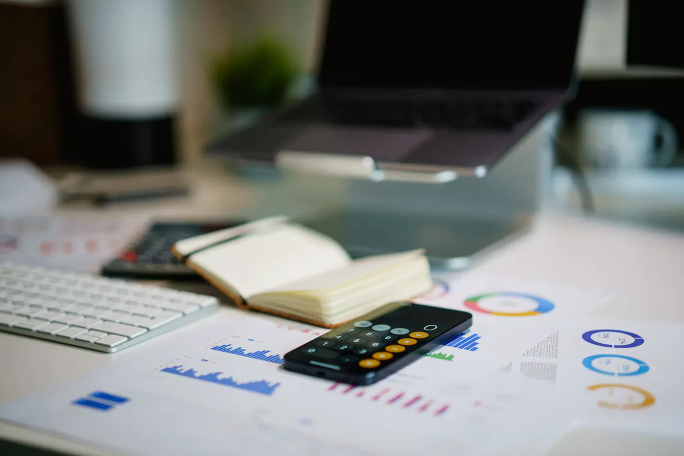 Escritorio con gráficos financieros y un teléfono